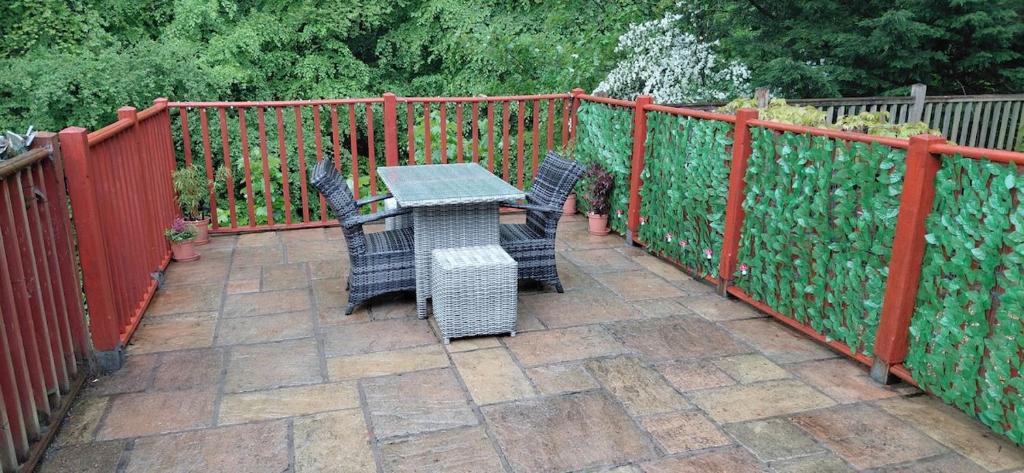 a patio with a table and chairs next to a fence at Kingfisher Cottage Wales in Llanidloes