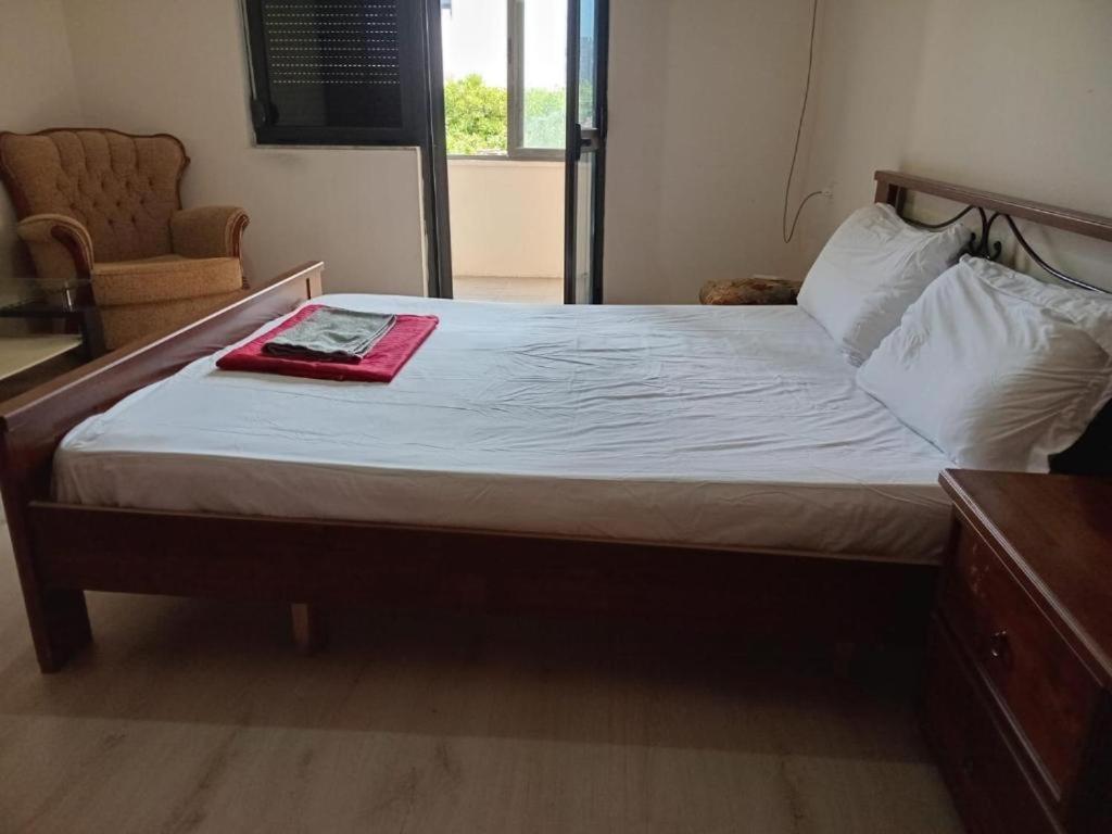 a bed in a bedroom with a red towel on it at Enjoy Hostel in Tirana