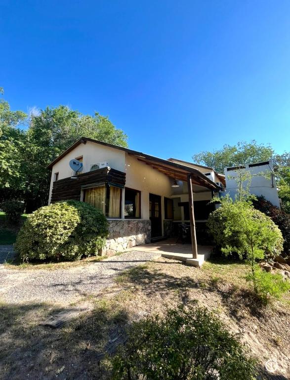 a small house with a porch and trees at Piedra Serrana in San Antonio de Arredondo