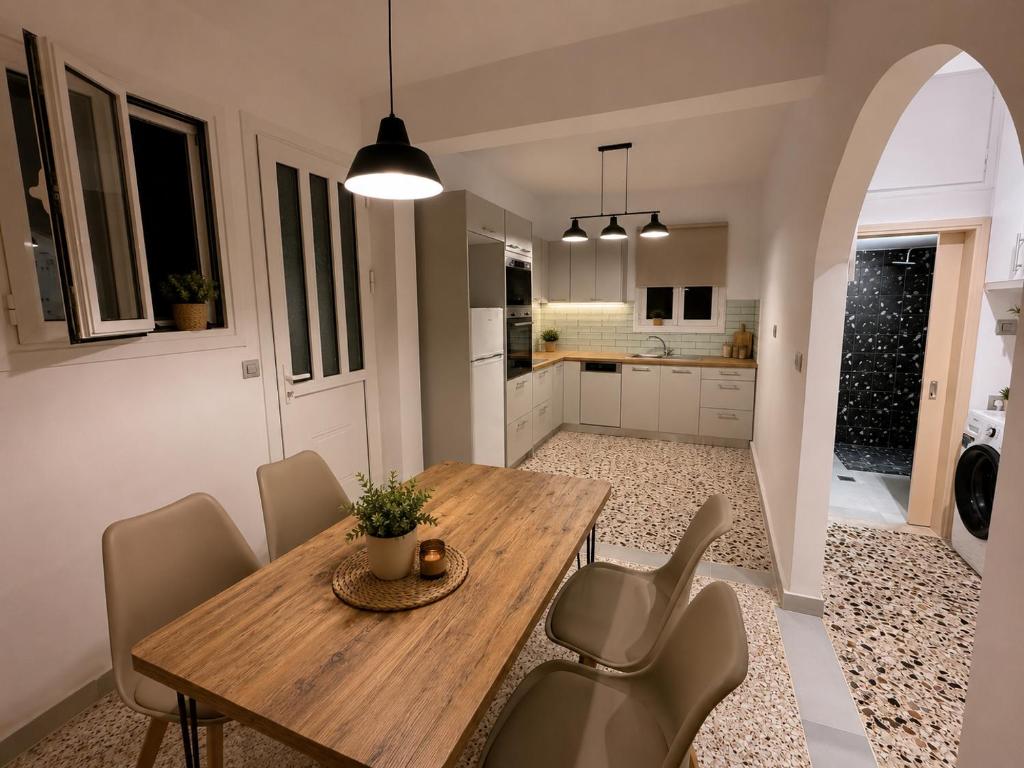 a kitchen and dining room with a wooden table and chairs at Mosaic House in Sami