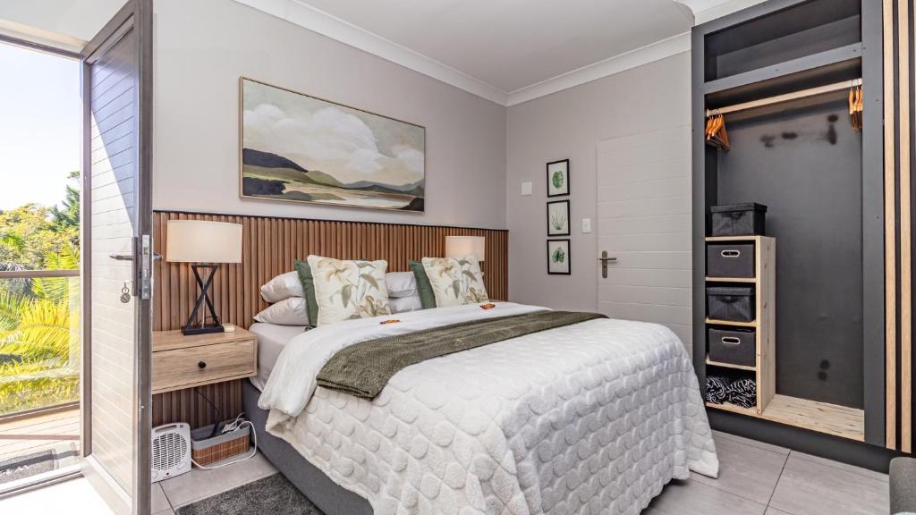 a bedroom with a large bed and a window at Studio Bella Vista Plett in Plettenberg Bay