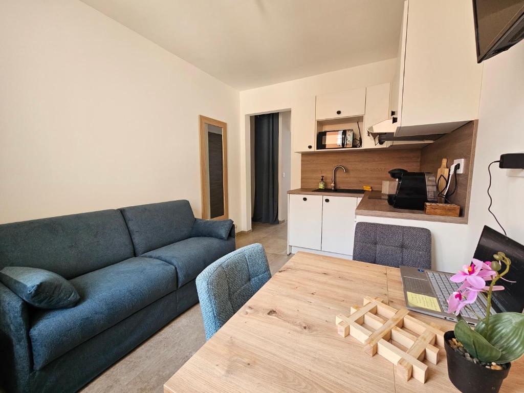 a living room with a blue couch and a table at Appartements sur l'ile de Porquerolles in Porquerolles