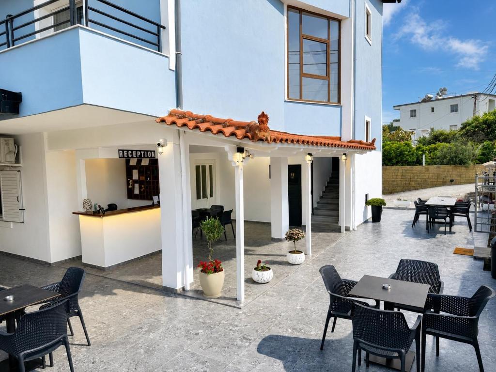 a patio with tables and chairs and a building at Hotel Elite in Ksamil
