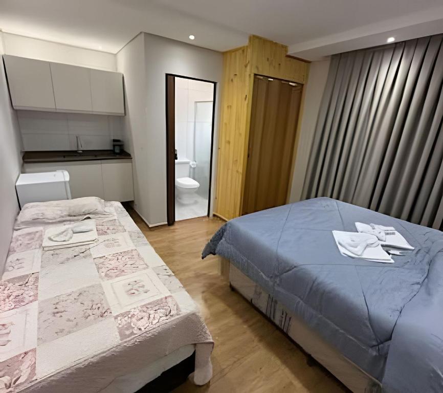 a small bedroom with a bed and a bathroom at Joseph Prime Studio Hotel Extrema MG in Extrema