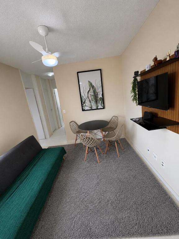 a room with a bed and a table and a tv at Apartamento 2 quartos ,Mobiliado em Sumare SP in Sumaré