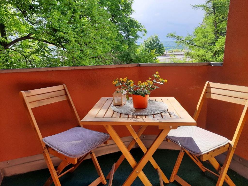 a table and two chairs on a balcony with a table and flowers at FEWO Geborgenheit ASZA mit strahlungsfreien Zonen in Bautzen