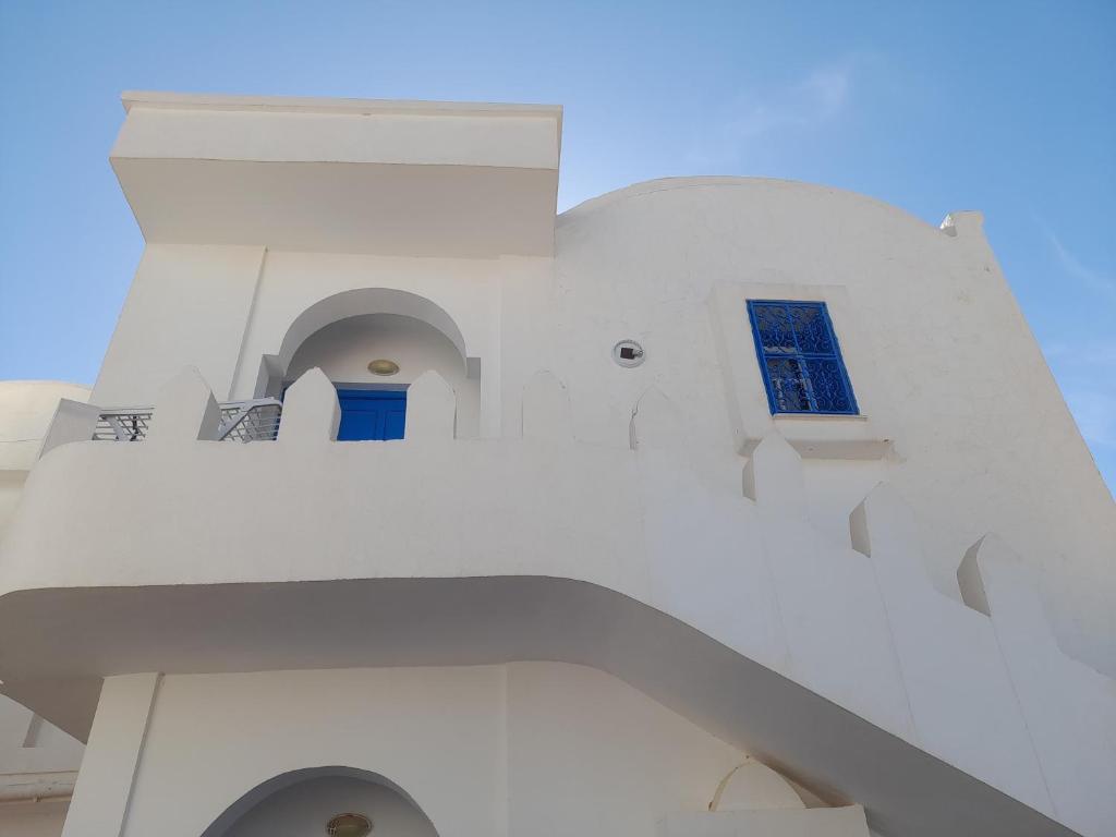 a white building with a blue window on it at Taguermess Tag 6 in Taguermess