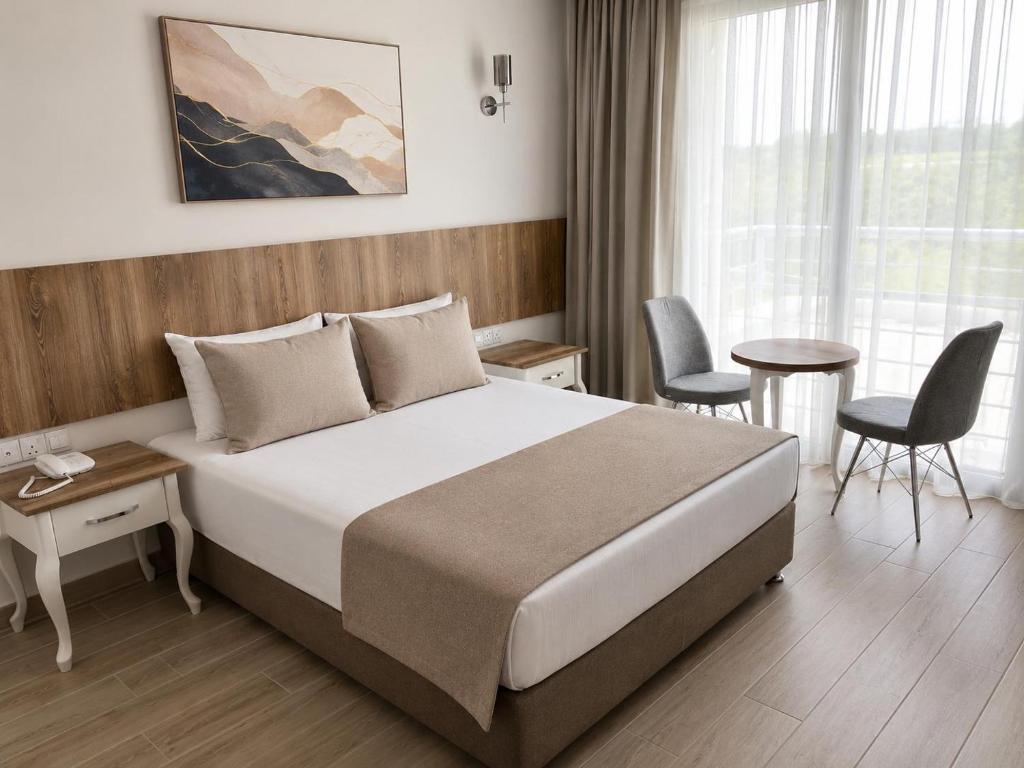 a hotel room with a bed and a table and chairs at Vel-Mer Lefke in Ayios Nikolaos