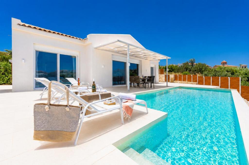 a villa with a swimming pool and a house at Casa di Pietra in Lakíthra