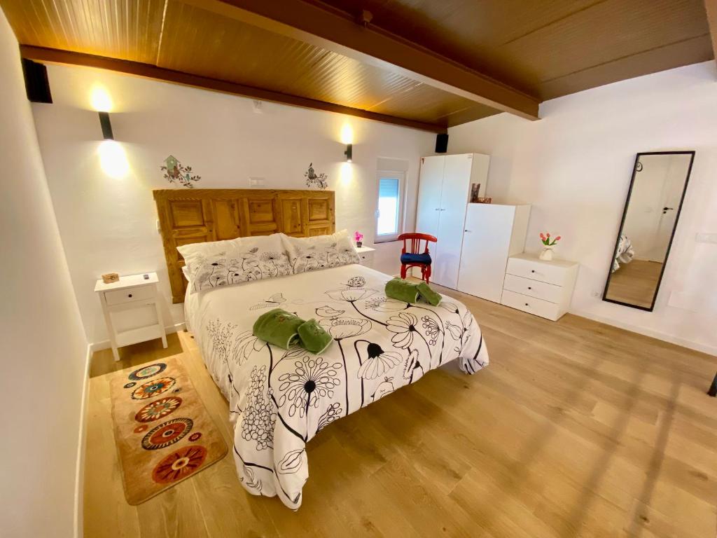 a bedroom with a large bed and a wooden floor at El Nidito del valle del Tietar in La Iglesuela