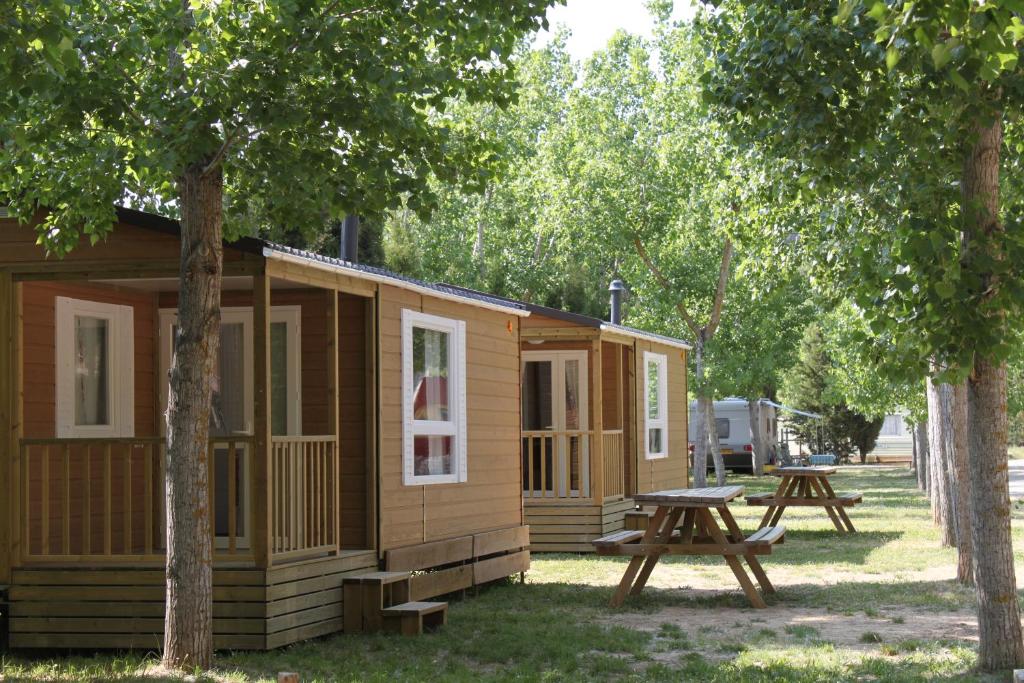 a cabin in the woods with a picnic table at Camping Rio Vero de Alquézar in Alquézar