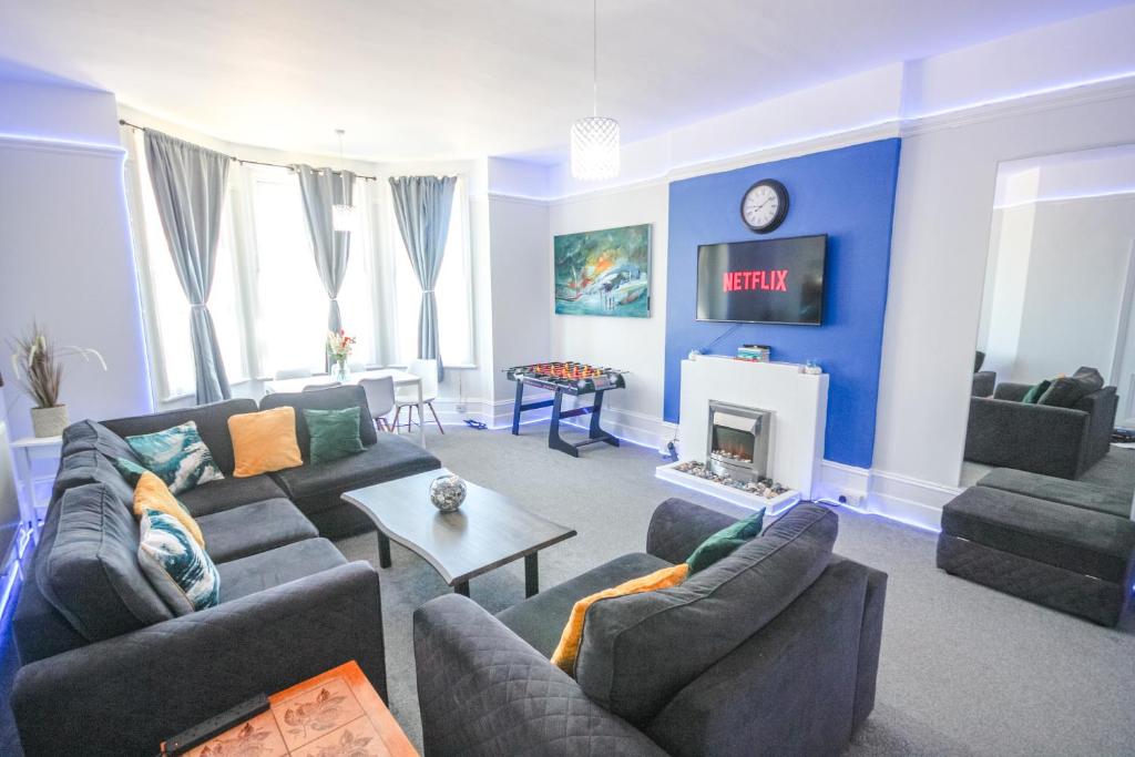 ein Wohnzimmer mit Sofas und einer Uhr an der Wand in der Unterkunft Spacious - 8ight Havens in Folkestone