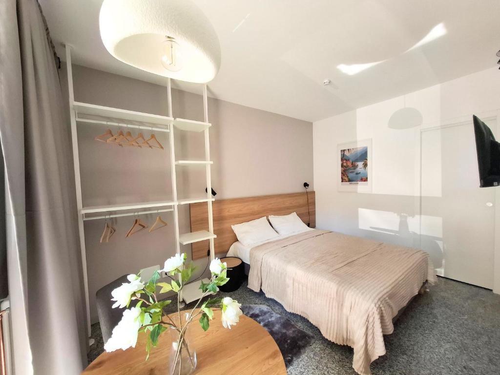 a bedroom with a bed and a table with flowers at Eva Urban Rooms Centro Lecco in Lecco