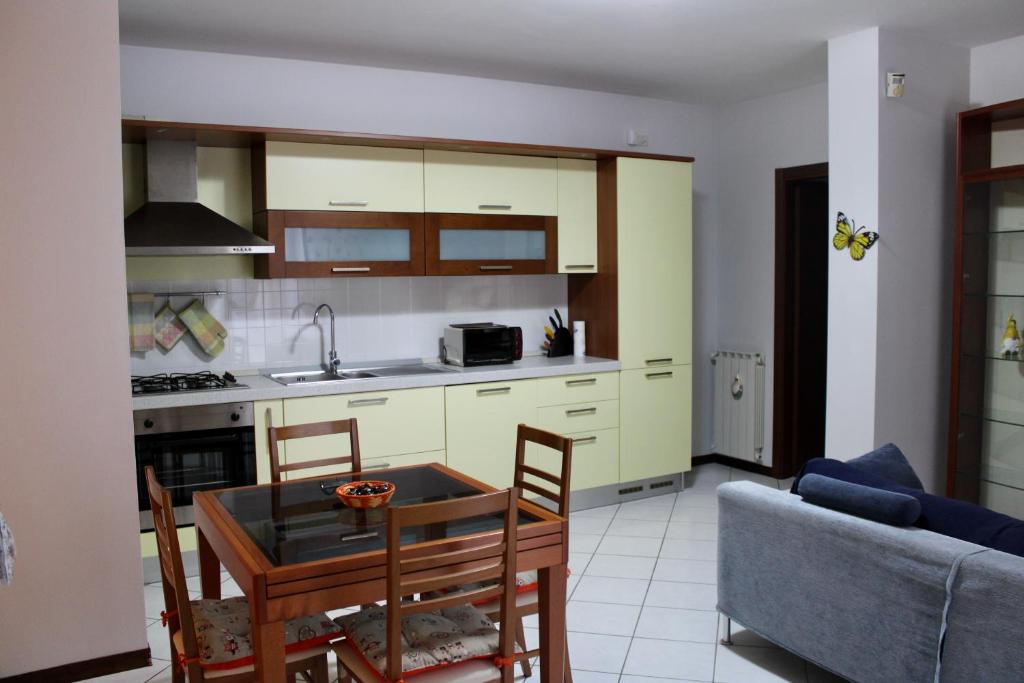 a kitchen and dining room with a table and a couch at nido delle farfalle in Stazione di Chiusi