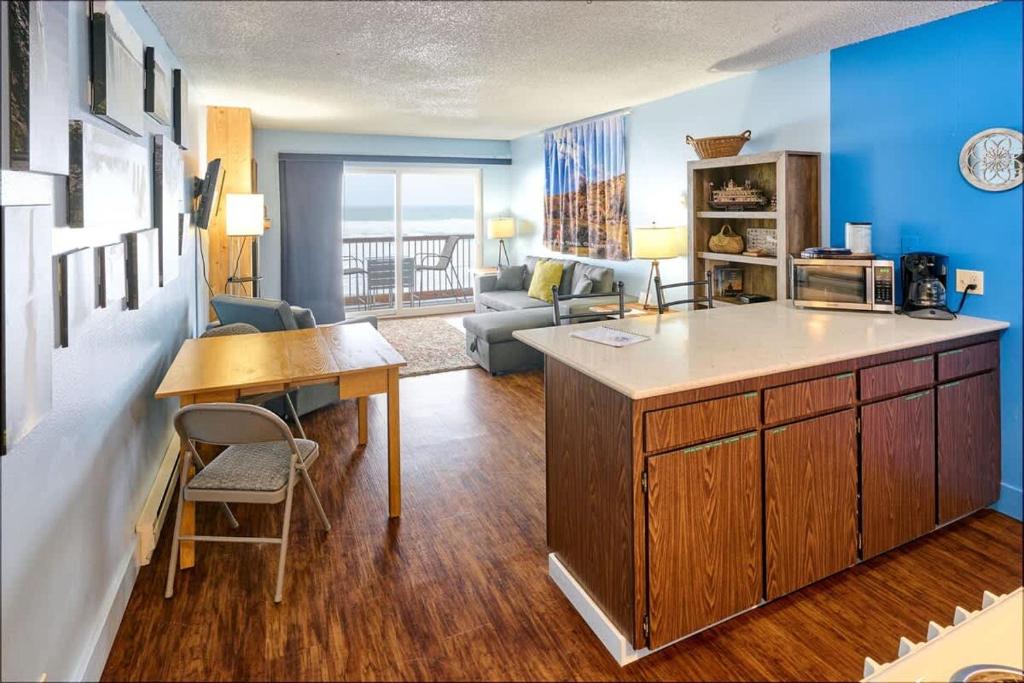 a kitchen and living room with blue walls and a table at Lovely Oceanfront Condo -Top Floor - Pet Friendly in Lincoln City