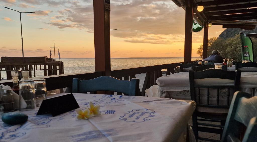 a restaurant with tables and chairs with a view of the ocean at Paralia Hotel & Taverna in Agia Roumeli