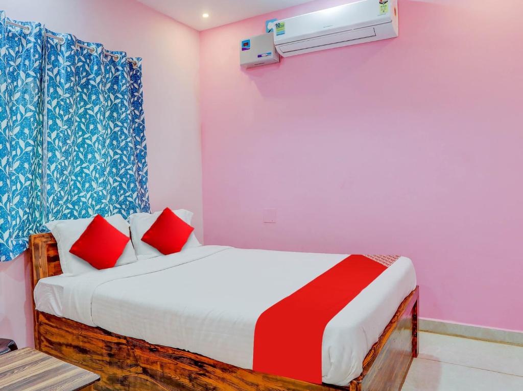 a bedroom with a bed with red pillows at Hotel O Kalinga Inn in Bhubaneshwar