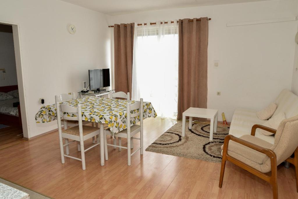 a living room with a table and chairs and a television at Blagdan Holiday in Kukljica