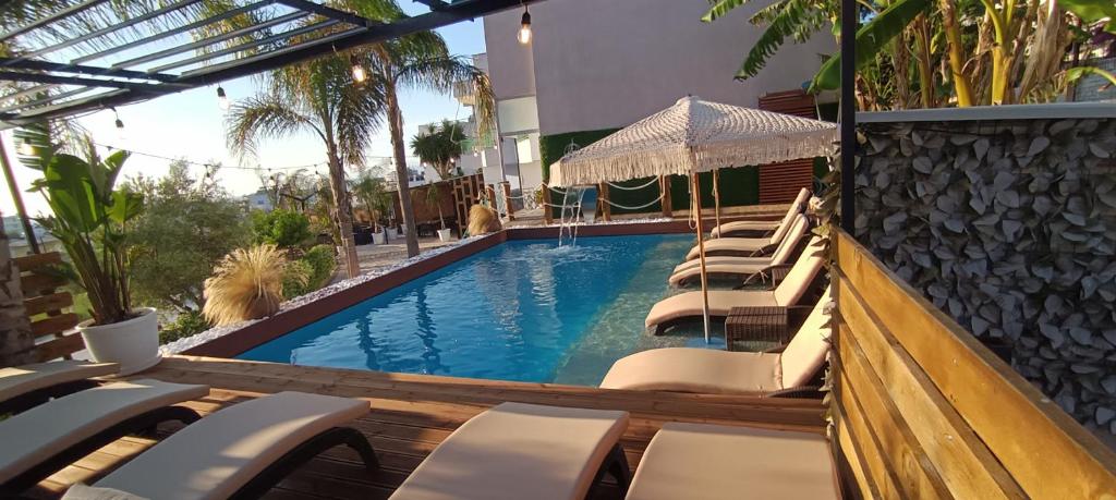 a swimming pool with lounge chairs in a hotel at Villa Nefeli Ksamil in Ksamil