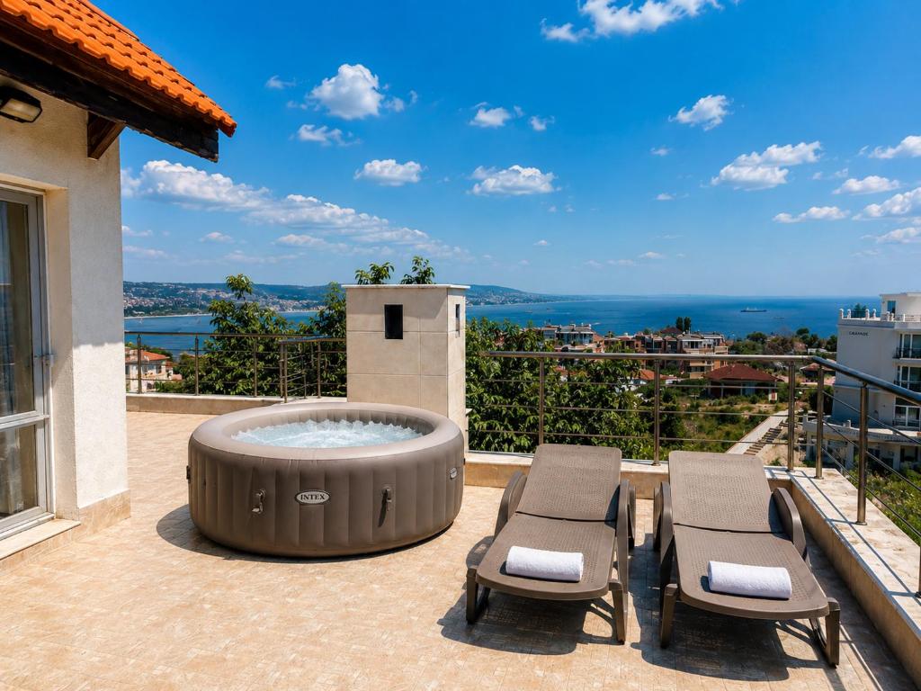 a patio with a hot tub and two chairs at Villa Avelia - Sea View Jacuzzi Retreat in Varna City