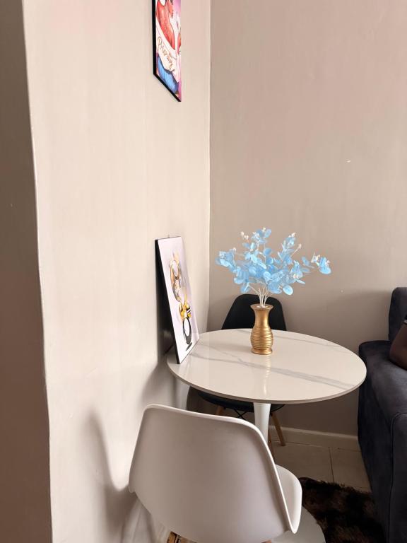 a white table and a chair in a room at HIDEOUT BnB with swimming pool in Kiambu