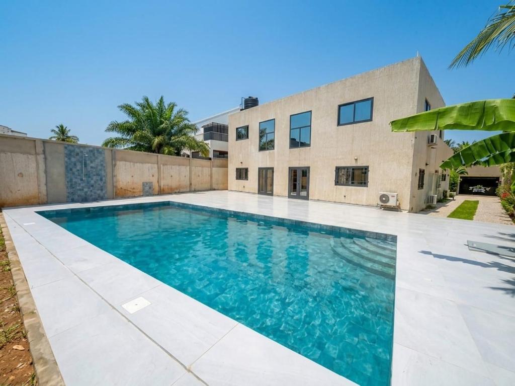 a swimming pool in front of a house at Villa Lawsmat avec piscine privée et grand jardin in Lomé