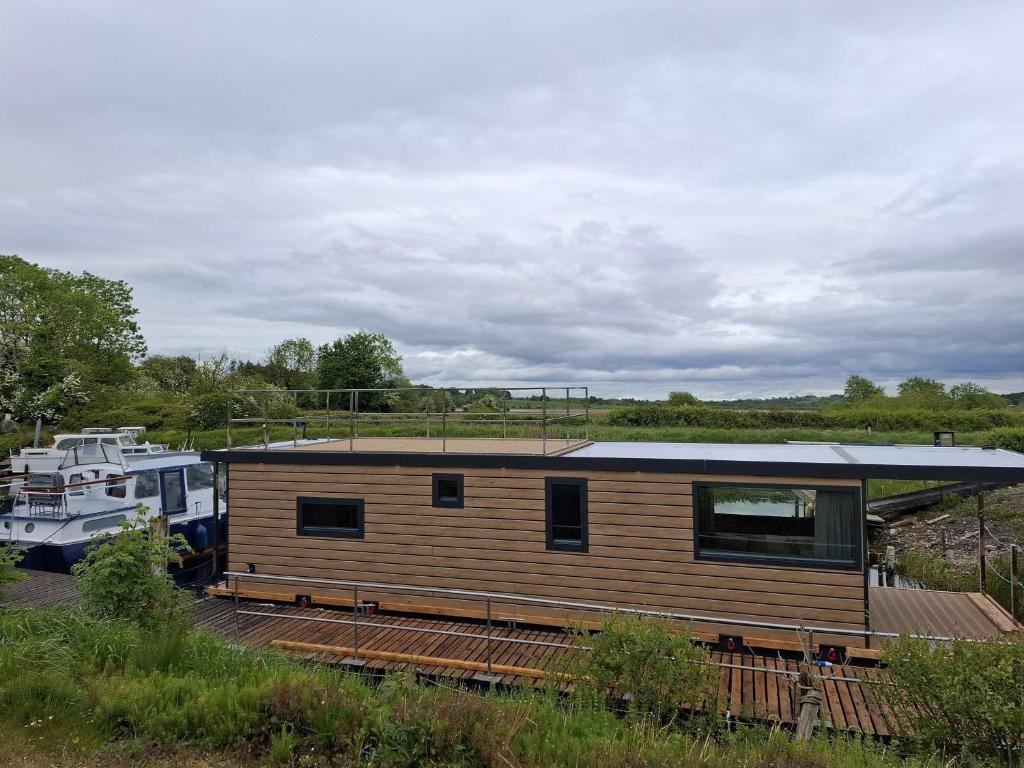 a tiny house is parked next to a boat at Aquastay Drift in Athlone