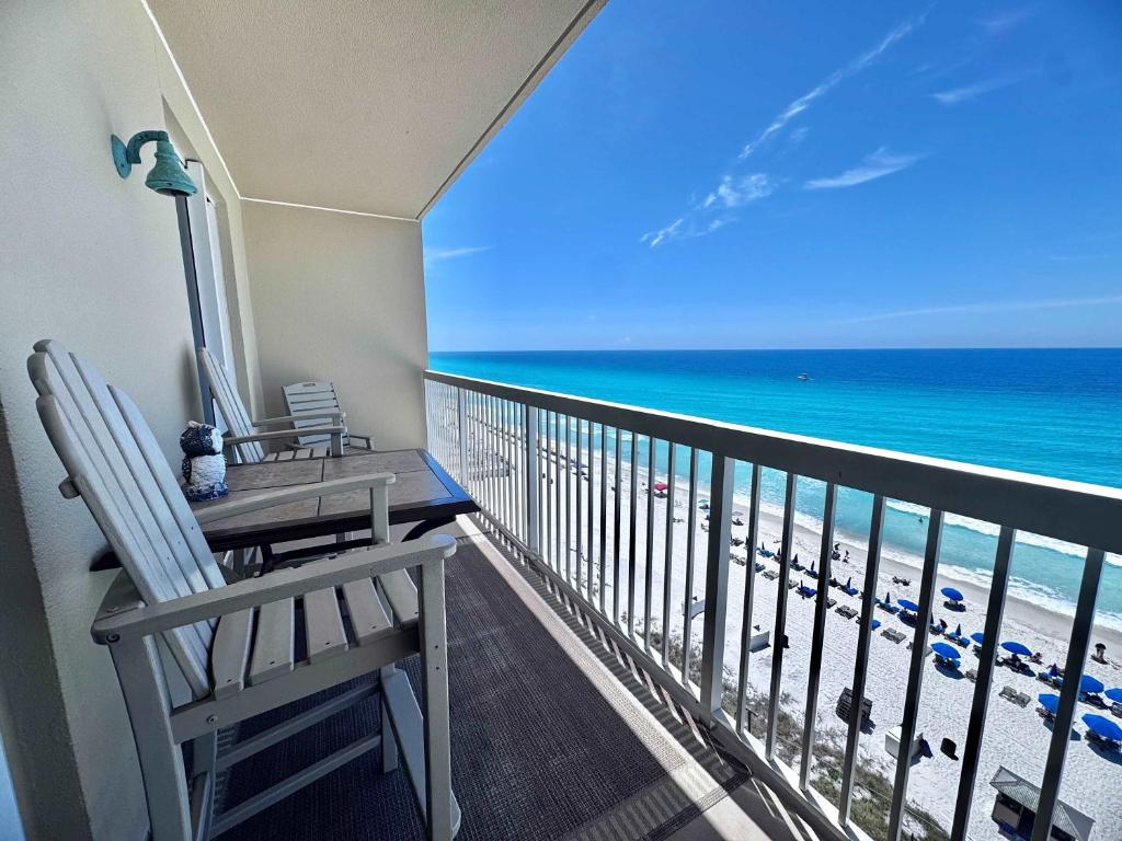 a balcony with a table and chairs and the ocean at 2 BR Oceanfront Condo with Shared Pool & Hot Tub in Panama City Beach