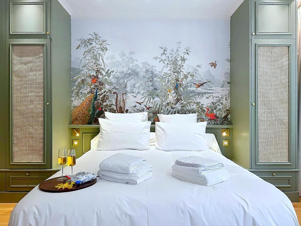 a bedroom with a white bed with towels on it at La suite du Brésil - Centre historique du Puy in Le Puy-en-Velay