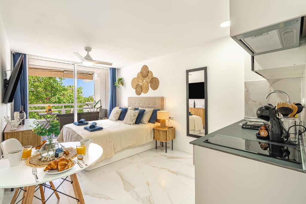 a bedroom with a bed and a table and a kitchen at Ocean Aura Tenerife in Costa de Adeje