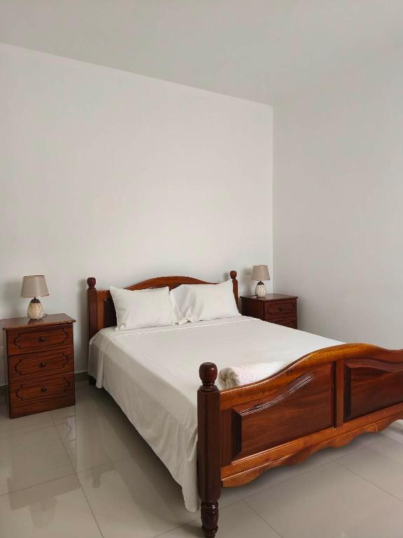 a bedroom with a wooden bed and two night stands at Ap Doce Lar in Espargos