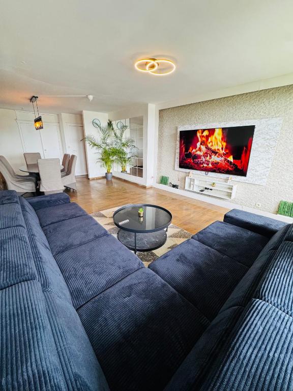 a living room with a blue couch and a fireplace at Appart meublé 92m2 + 2 terrasses in Brussels