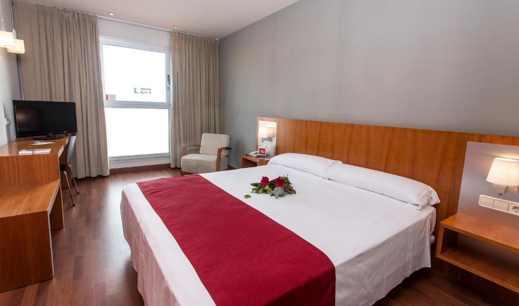 a hotel room with a large bed with flowers on it at Hotel AG Express Elche in Torrellano