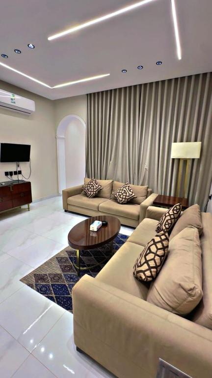 a living room with two couches and a table at شقق الياسمين الفندقية in Medina