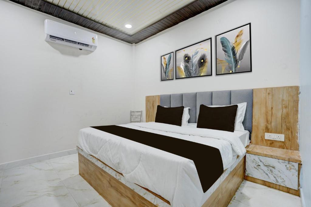 a bedroom with a large bed with three pictures on the wall at Hotel O Viraj Inn in Gwalior