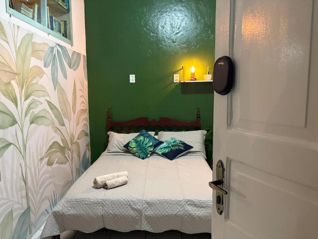 a small bedroom with a bed with a green wall at Quarto confortável no Centro- Wi-Fi rápido, ar-condicionado in São Luís