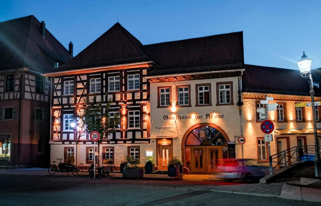 a building on a street with a car driving past it at Gasthaus zur Krone in Weingarten (Karlsruhe)
