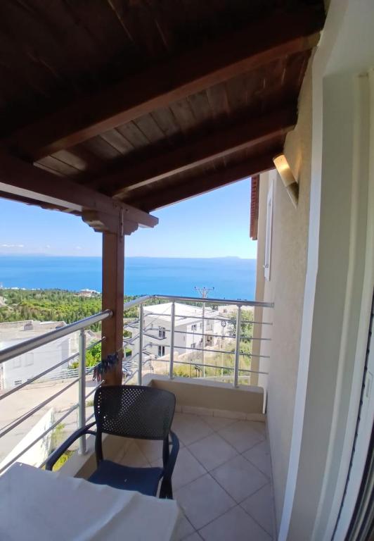 a balcony with a chair and a view of the ocean at RAHI Rooms in Gjilek