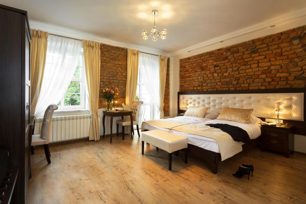 a bedroom with a large bed and a brick wall at Aparthotel Wodna in Poznań