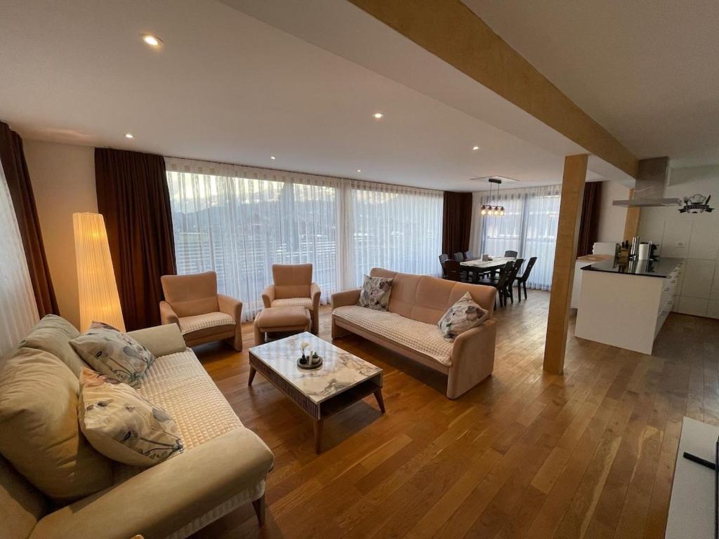 a living room with couches and a table and a kitchen at Apart Falke 2 am Wasserfall in Unterbach
