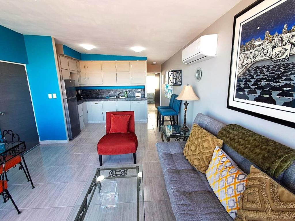 a living room with a couch and a red chair at Stunning Azul Ocean View Apartment in San Carlos