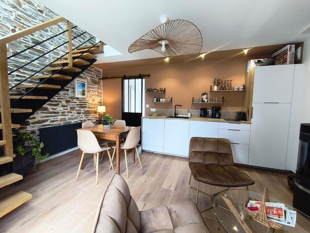 a kitchen and living room with a table and chairs at Ty Noa - 2-bedroom cottage in Saint-Just