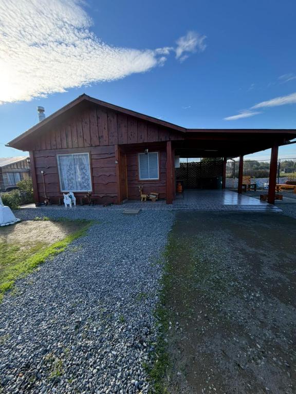 a large wooden cabin with a gravel driveway at Cabaña el ricky in Cabrero