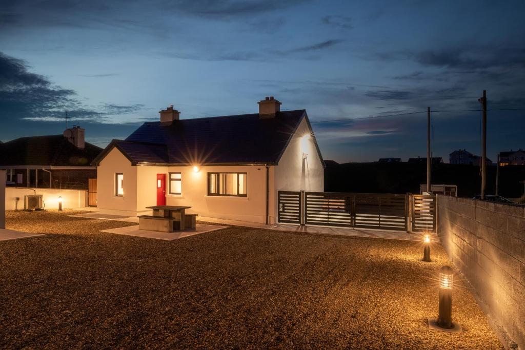a white house with lights in front of it at Gorgeous Luxury in Lahinch