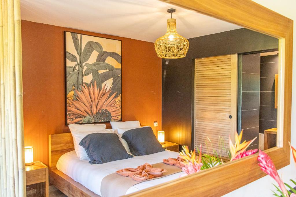 a bedroom with a bed with a painting on the wall at Village Soleil in Le Gosier