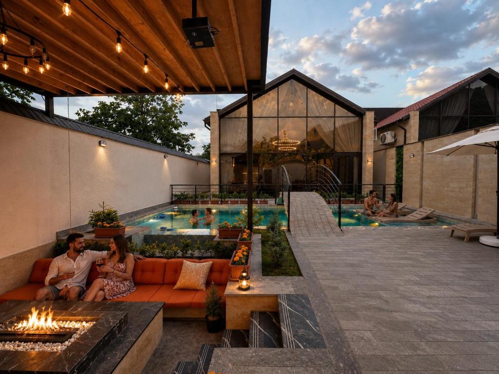 a man and woman sitting on a couch next to a swimming pool at Qafqaz Suite Wood Stack in Gabala