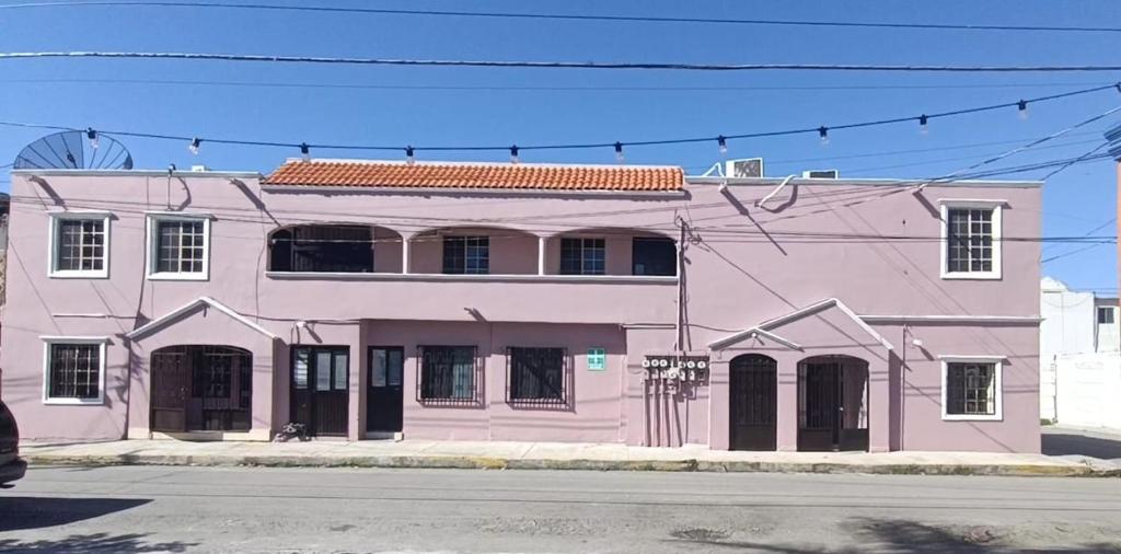 a pink building on the side of a street at Garcias Suites Cuauhtémoc in Linares