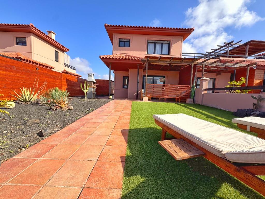 a backyard with a bench and a house at Casa Bali in Majanicho