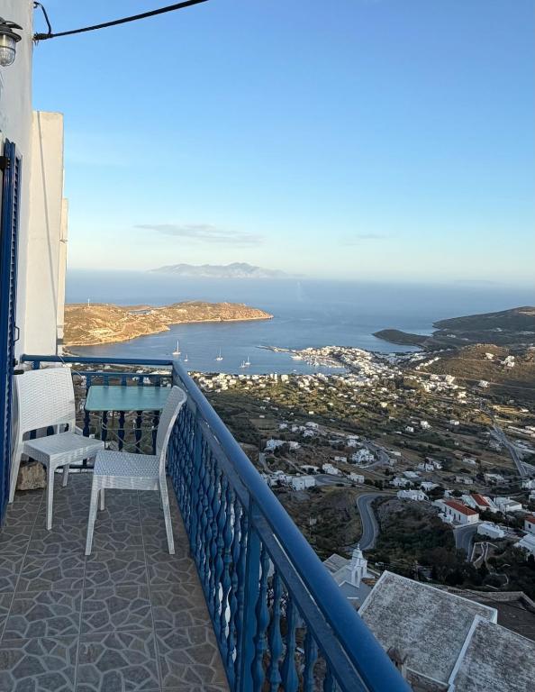 a balcony with a table and chairs and the ocean at Camaraki Hill House Serifos in Serifos Chora
