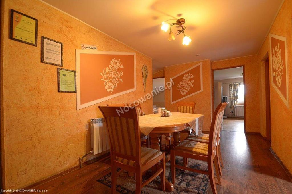 a dining room with a wooden table and chairs at Agroturystyka U Marty in Trzcinica